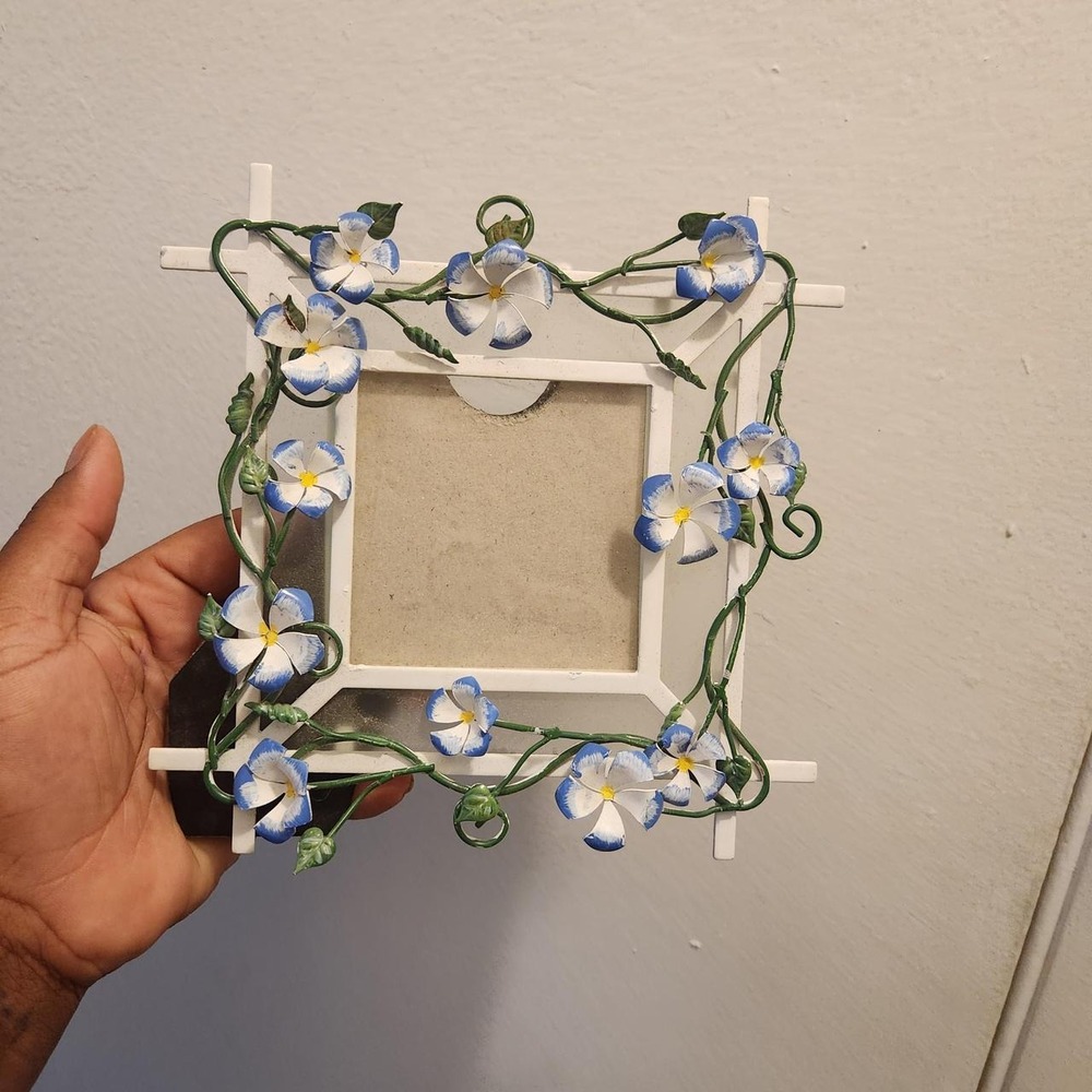 Vintage-style metal picture frame featuring delicate blue and white flowers